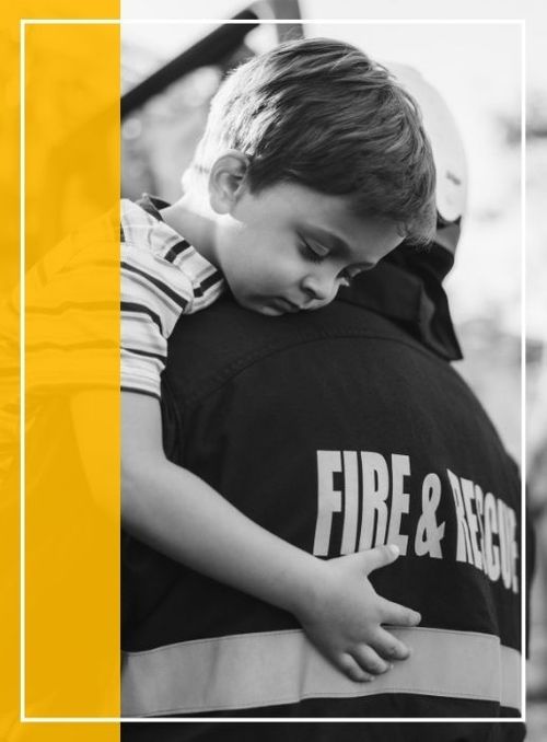 Image of a child hugging a fire & rescue worker